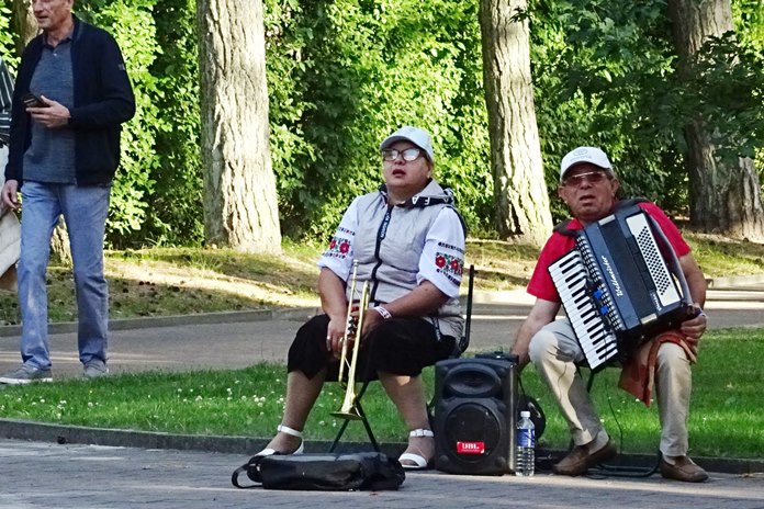Gatvės muzikantai groja akordeonu ir trimitu Palangos parke.